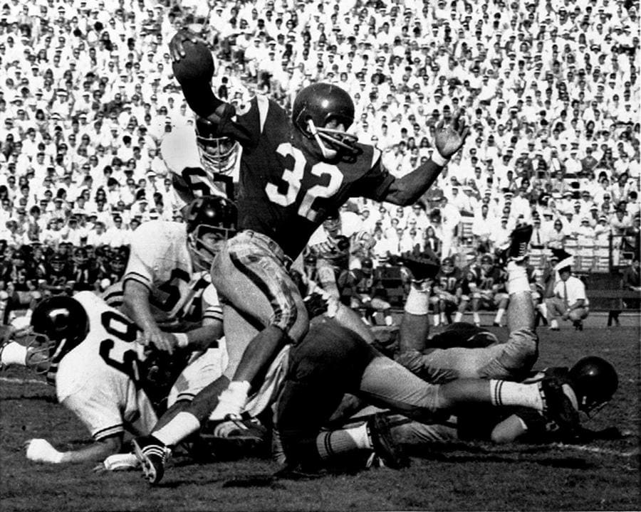 Photograph of OJ Simpson (32) runs against rivals from Cal Berkely during an NCAA game in LA.