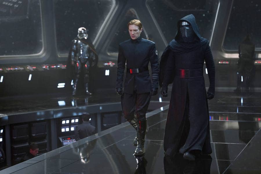 Oscar Isaac, Domhnall Gleeson, and Adam Driver all in character from a scene in Star Wars. 