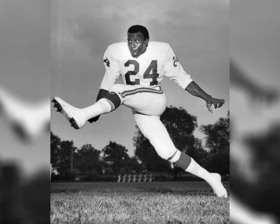 Fred Williamson in uniform kicking a football.