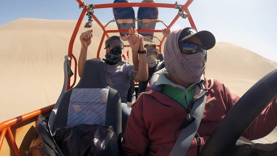 The Bachelor and his date are riding in an ATV through the sand dunes. 