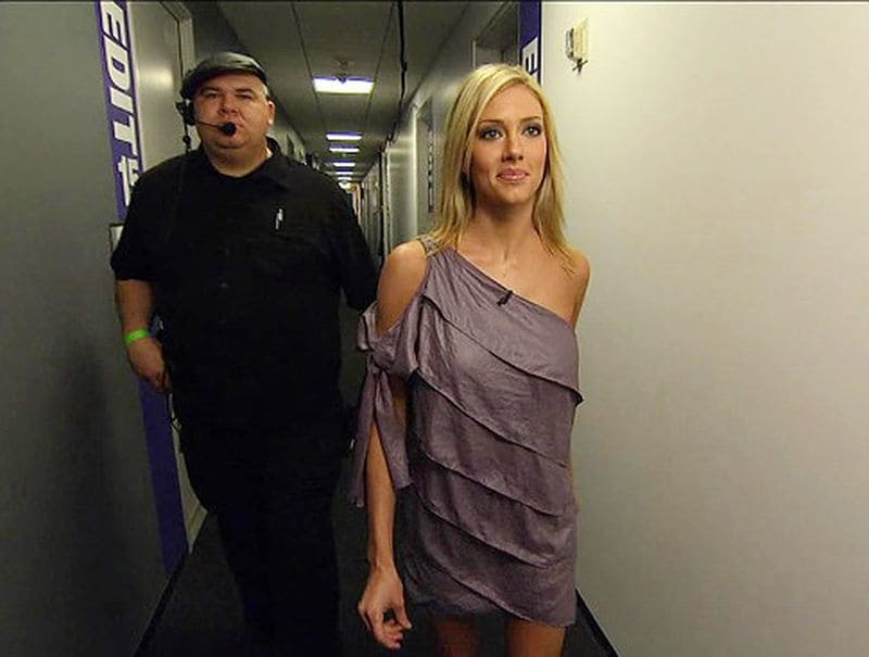 Rozlyn Papa being escorted to the stage in a purple off the shoulder dress after she was kicked off of the show. 