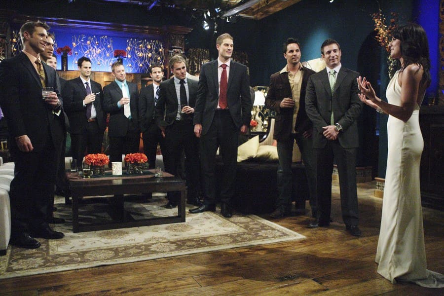 Photograph of the Bachelorette Jullian Harris talking to her room full of bachelors. 