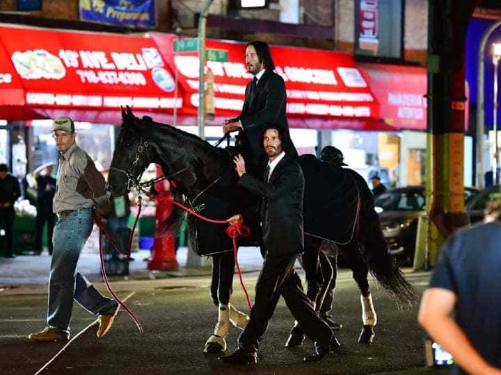 Keanu Reeves and Jackson Spidell are standing together in similar black clothing.