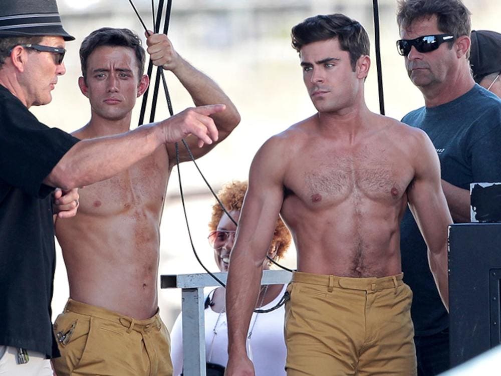 Zac Efron and Jordon Scott are standing around shirtless on the set of Dirty Grandpa.