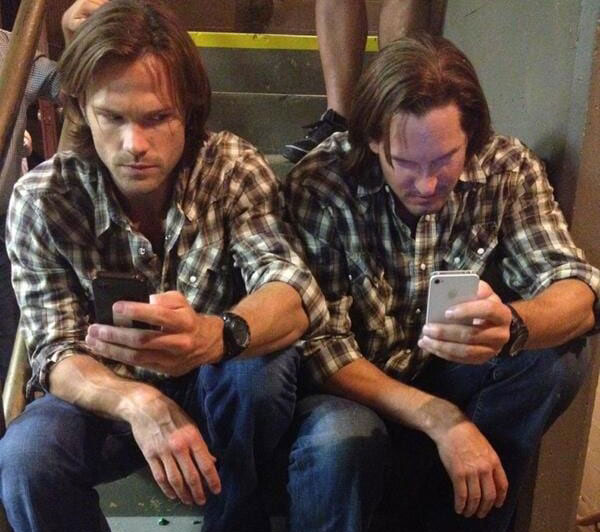 Jared Padalecki and Mike Carpenter in matching brown and white plaid shirts.
