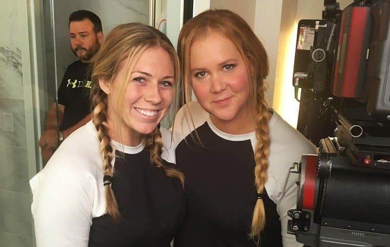 Amy Schumer and Meredith Richardson in matching black and white baseball t-shirts.