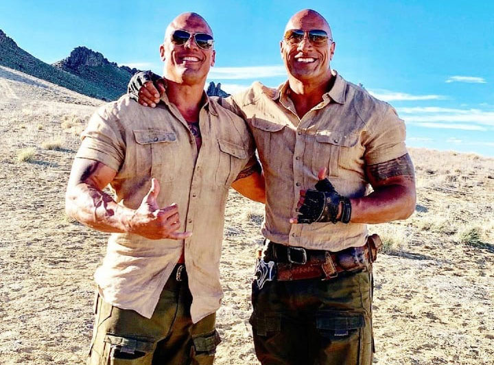 Dwayne Johnson and Tanoai Reed in matching tight short-sleeved shirts.
