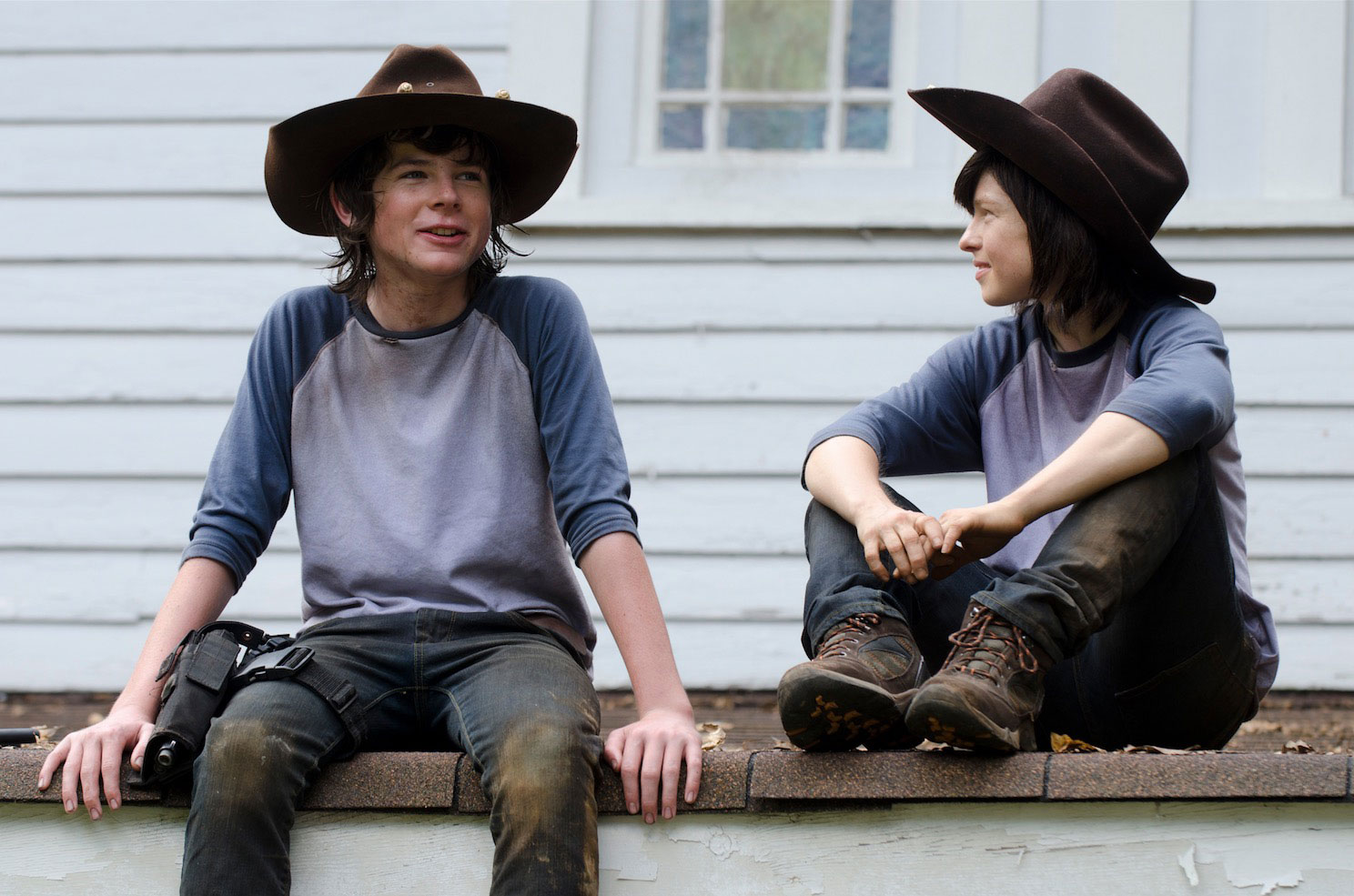 Chandler Riggs and Emily Brobst both dressed as young ranchers with cowboy hats.