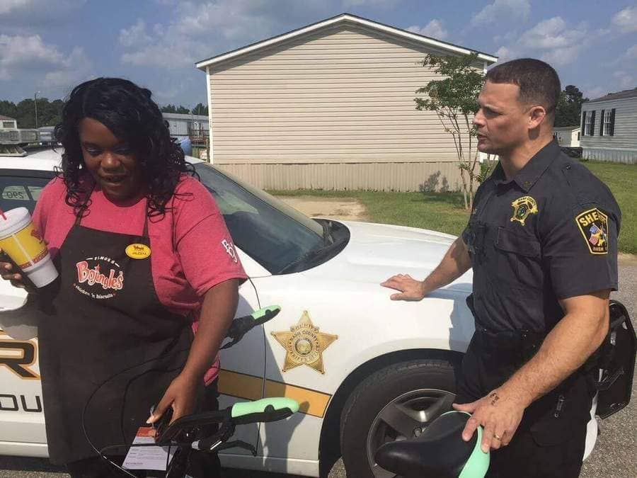 Officer Bass and Jayleysa Corbett next to a police car