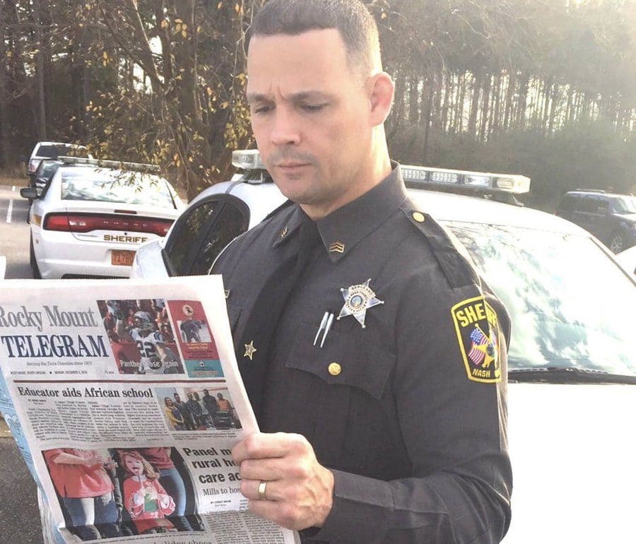 Officer Scott Bass looking at a newspaper