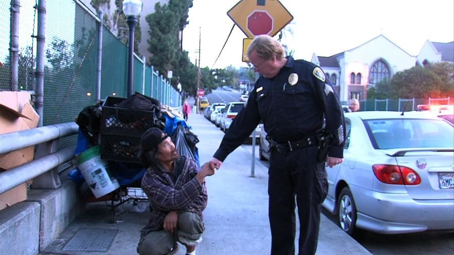 Cop shaking hands with a homeless man