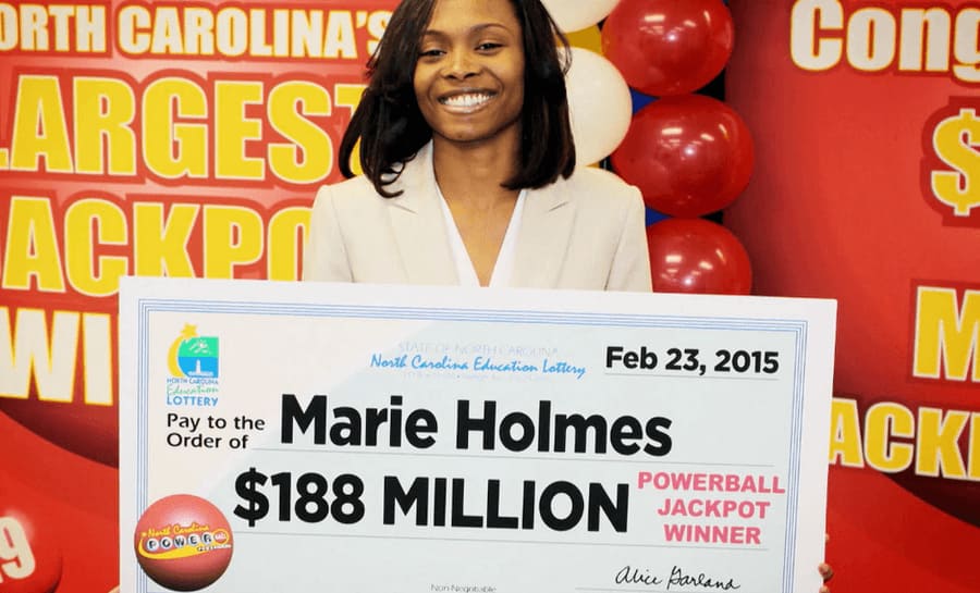 Marie Holmes photographed in front of balloons holding up her check for $188 Million on February 23rd, 2015.