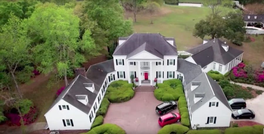 A birds-eye view of Marie Holmes' new white home with a grey roof, black shutters, and a red front door after she won the lottery.