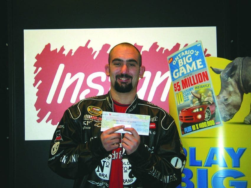 Photograph of Dan Carley, then 24, proudly displaying his lottery winnings in 2006.