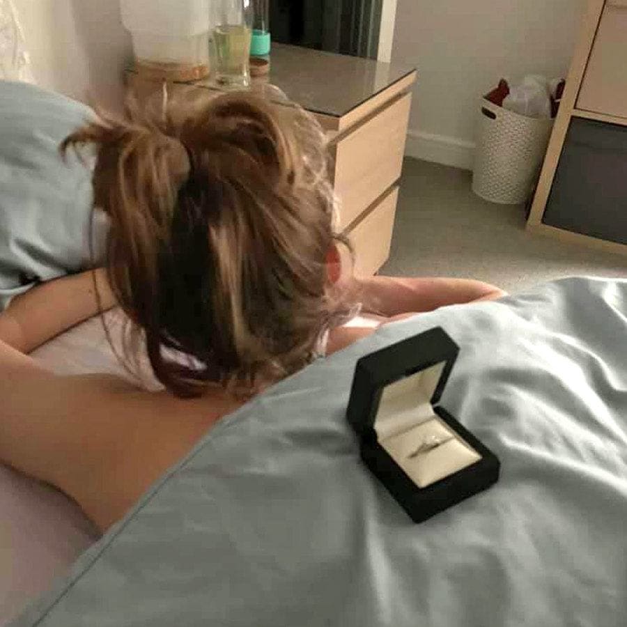 The engagement ring is sitting on Cally’s back while she lays in bed, scrolling through her phone. 