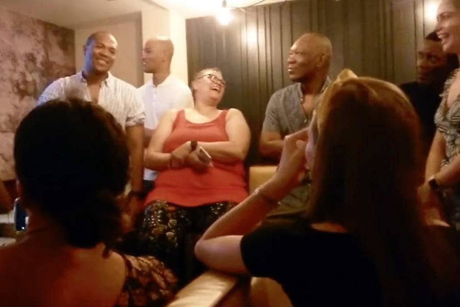 Edi and Cally with their family sitting around the couches. 