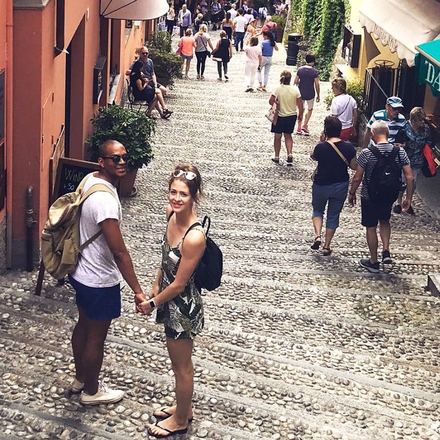 Cally and Edi are standing on a long set of stone steps on a cute street in Italy. 