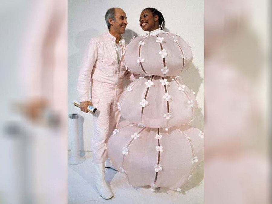 A bride wearing a pink layered dress and her groom