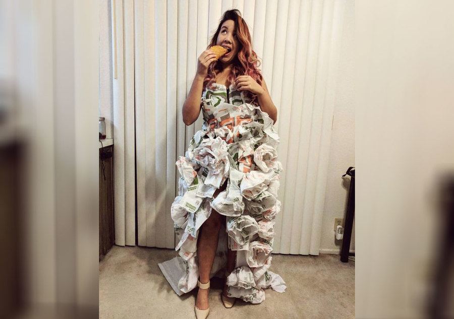 A girl eating a taco wearing a taco bell wedding dress