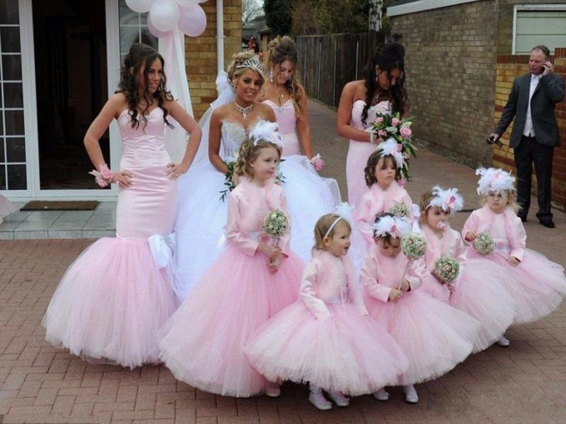 A bride wearing a crown and her bridesmaids wearing pink