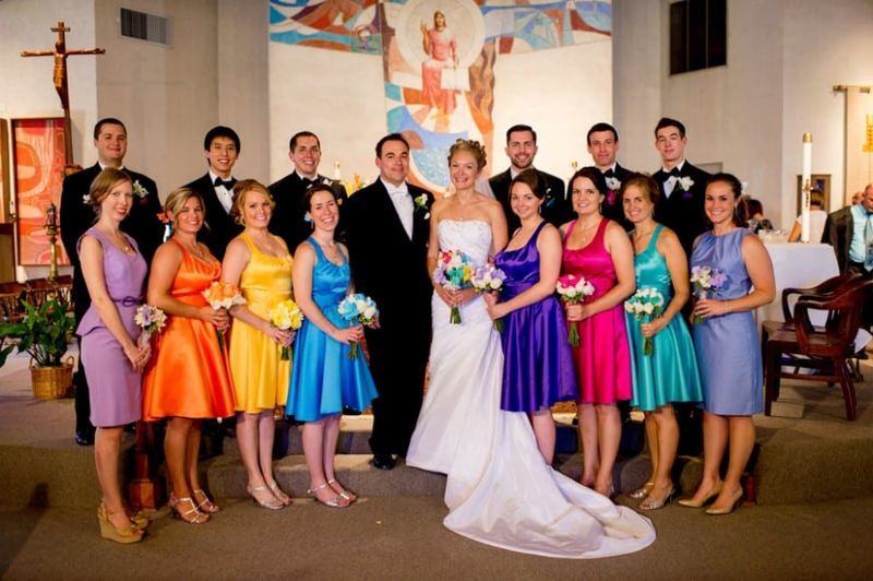 A bride and her bridesmaids wearing different colors