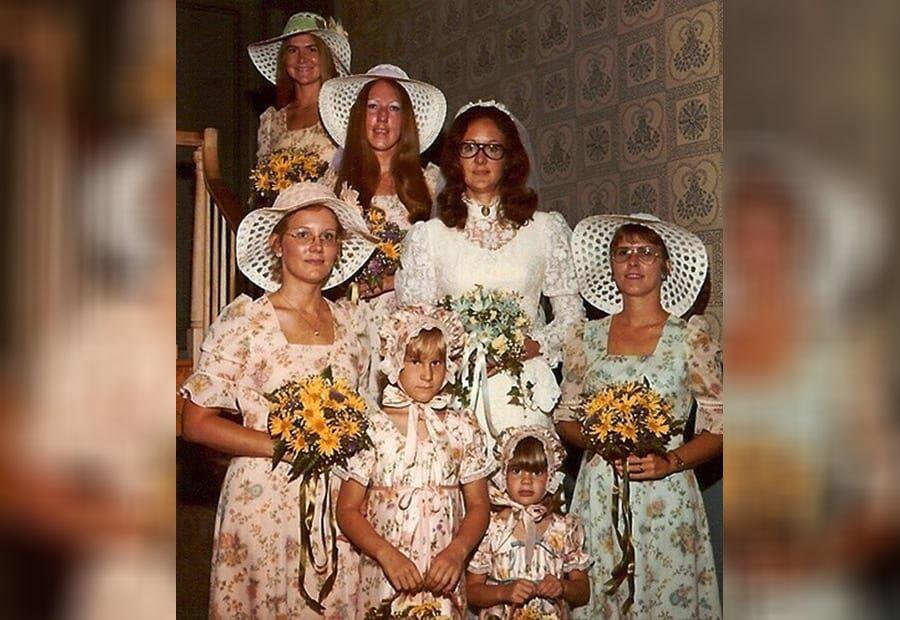 A bride wearing glasses and her bridesmaids wearing ugly hats