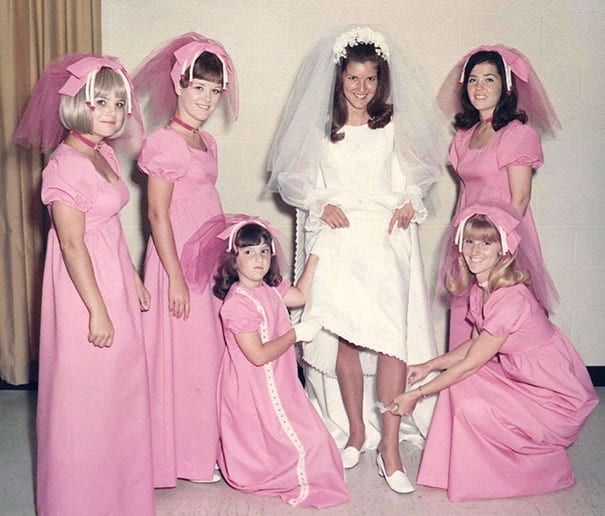 A bride and her bridesmaids wearing ugly pink bows