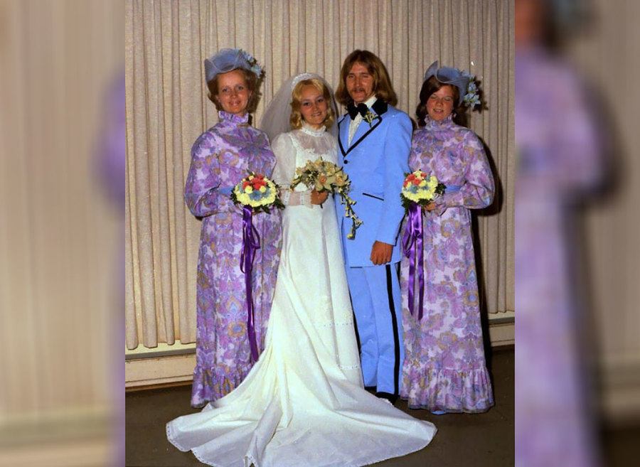 Bridesmaids in ugly purple dresses posing with the bride and groom