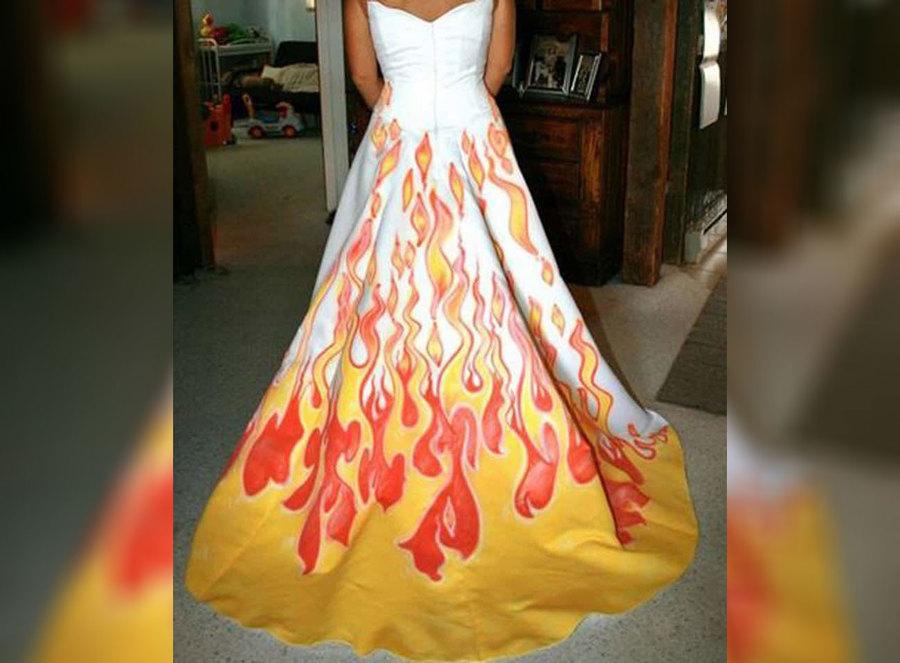 A wedding dress with fire drawn on the bottom of it