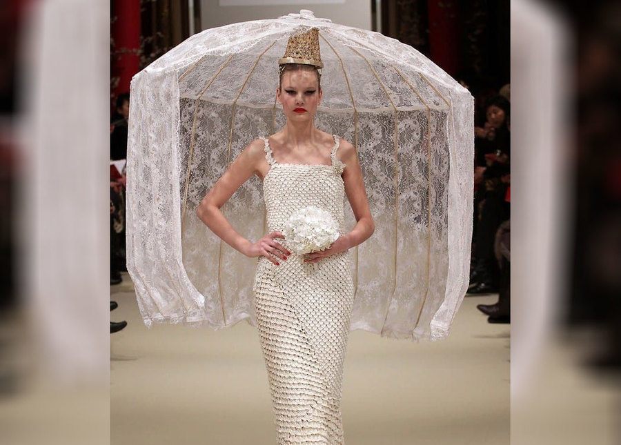 A bride wearing a dress with a huge lamp hat