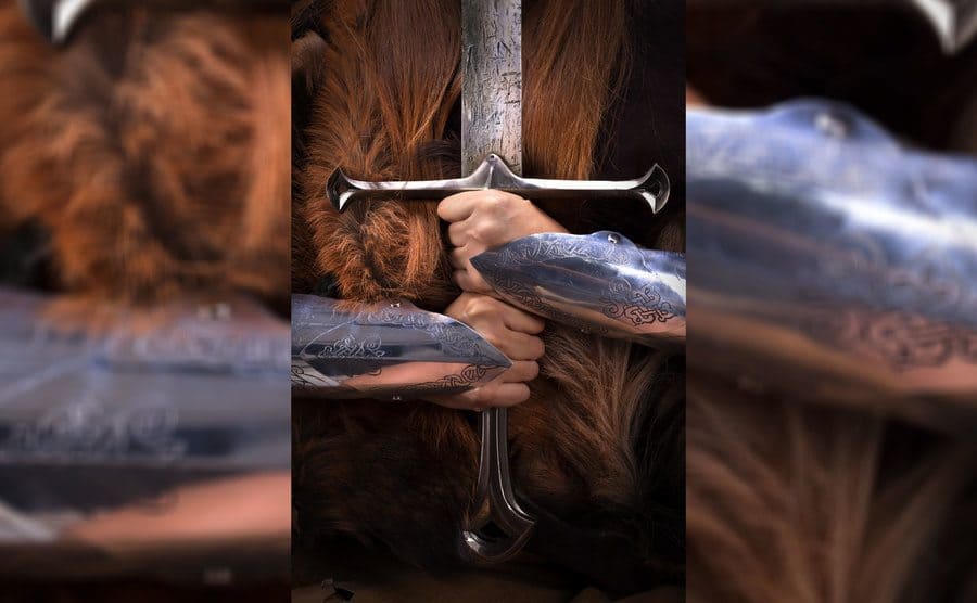 A redheaded girl as a shield maiden Viking warrior holding a sword