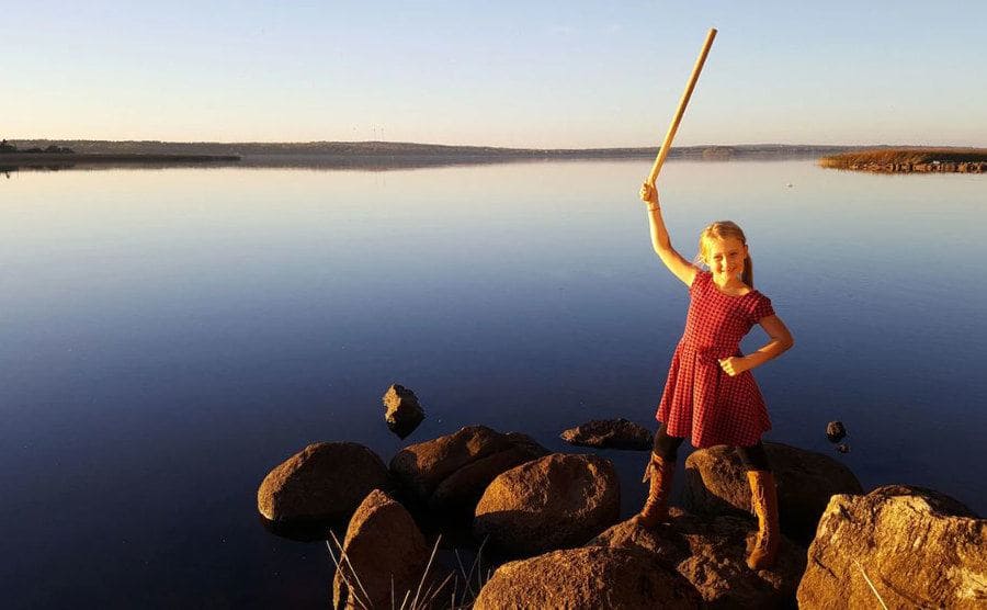 Saga poses by the lake with a wooden imitation sword
