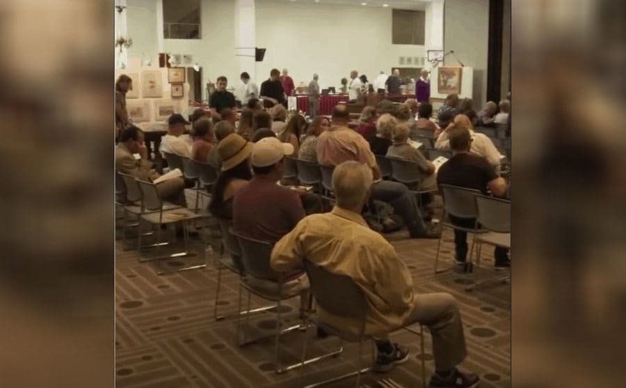 A photograph of the auction house with everyone sitting in chairs lined up 
