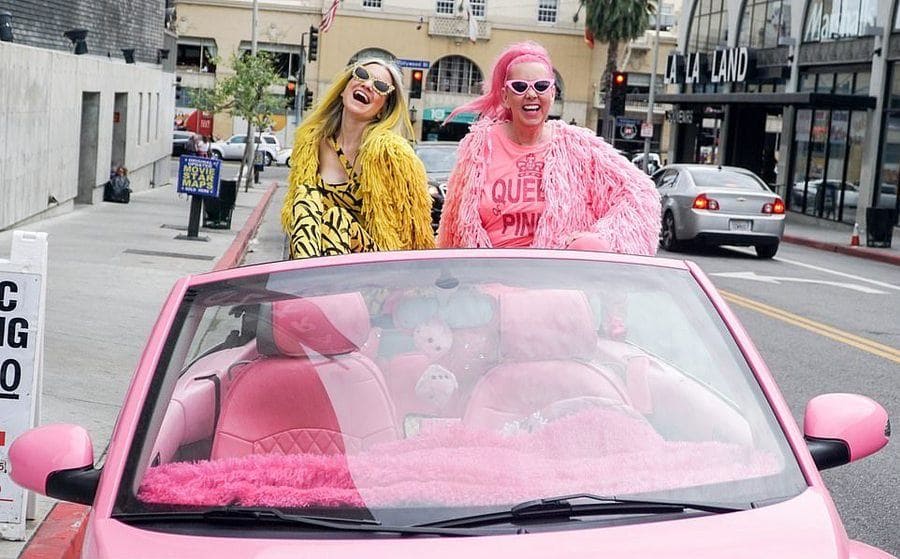 Ella London in all yellow and Kitten Kay Sera in all pink sitting in Sera's all pink custom car