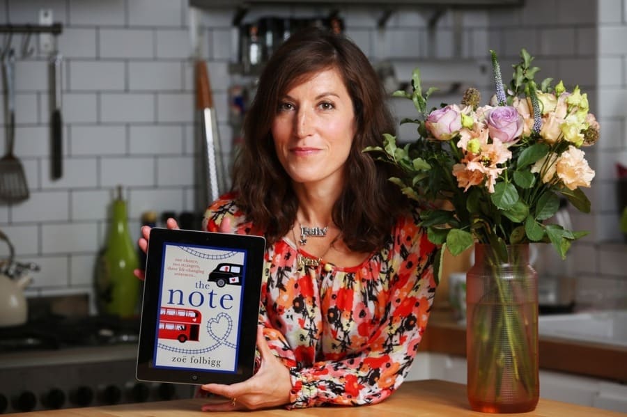 Author Zoe Folbigg holding her book