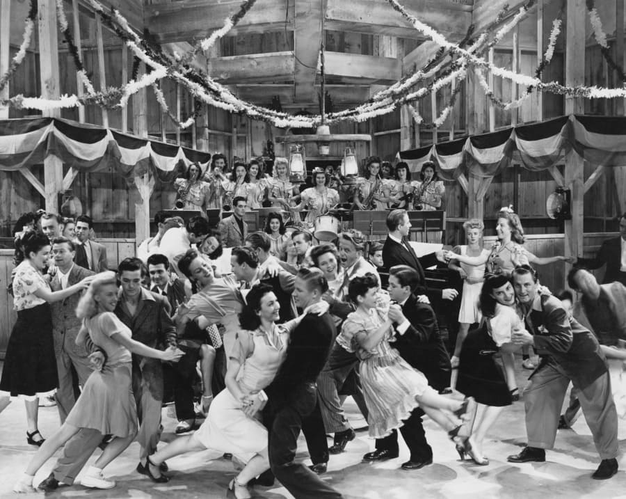 A photograph of people dancing around a bar together 