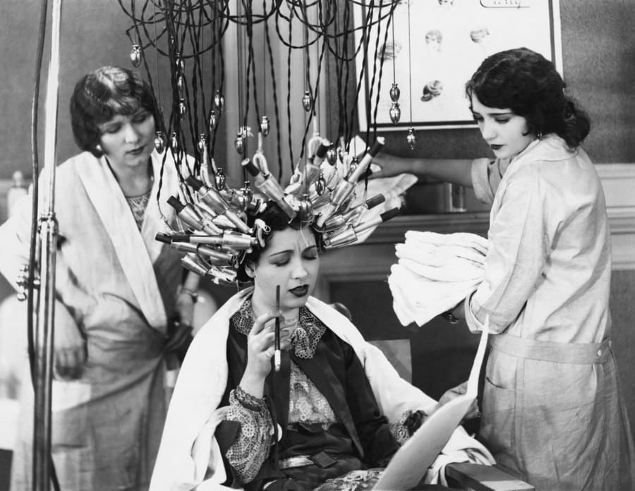 Photograph of a woman at the beautician getting her hair curled 