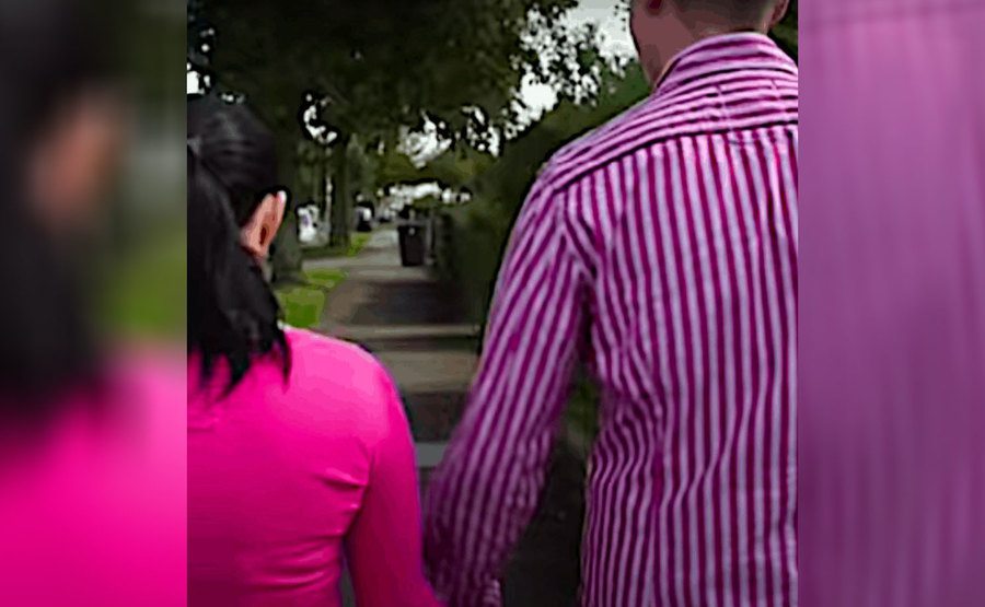 Lana and Michael hold hands and walk along the street