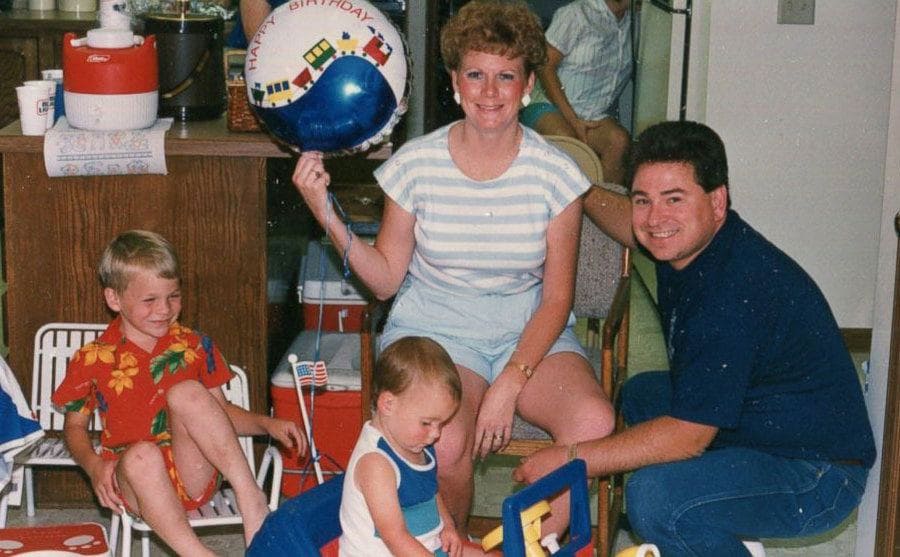 Richard and Linda with their two sons posing next to their kitchen