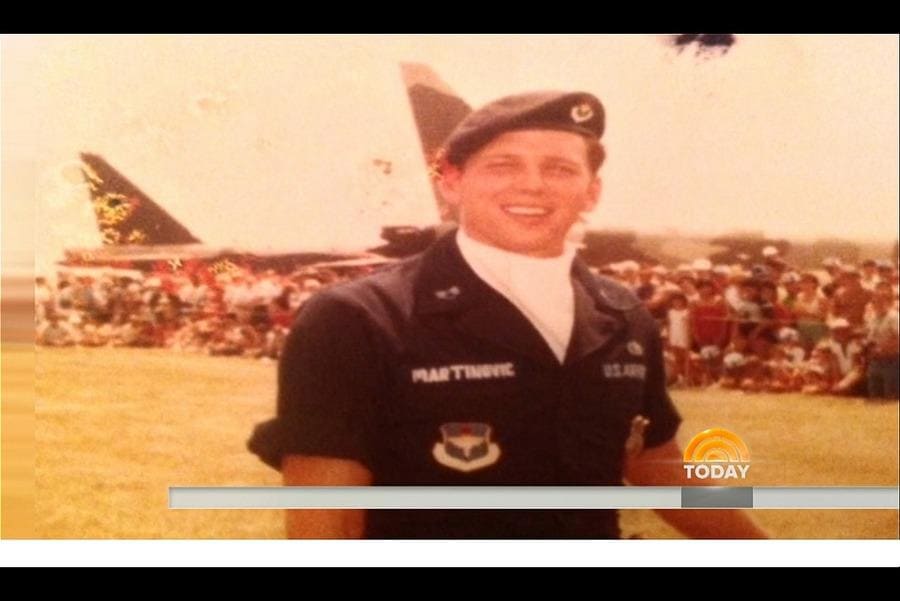 Marty in his military outfit stands in front of a plane