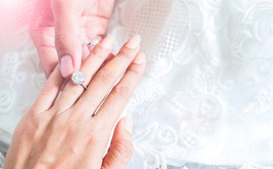 A man holding onto an engagement ring on a woman's hand 