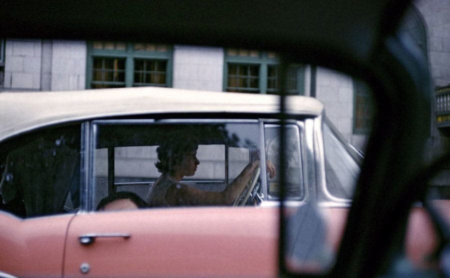 A woman in a pink car
