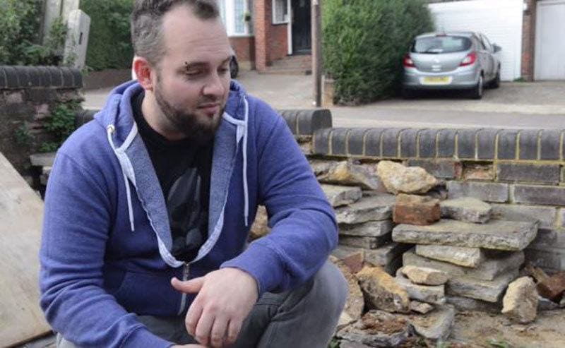 Simon Marks kneeling in his driveway