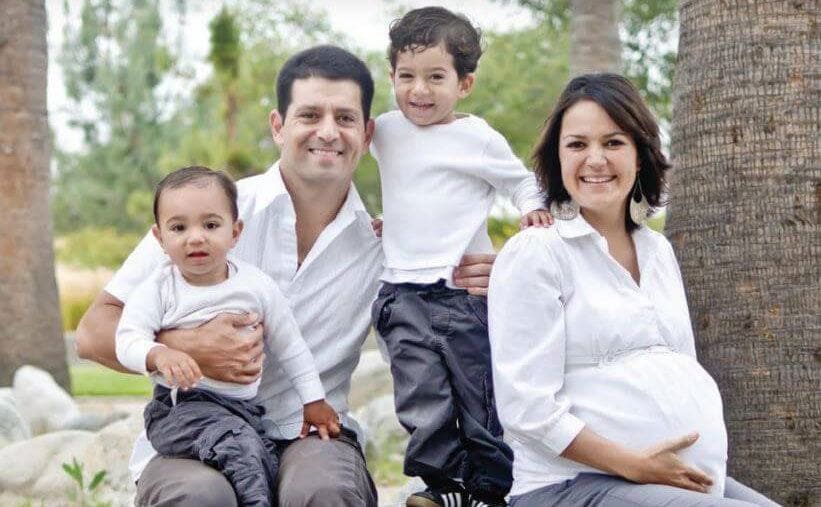 Angie and Gino posing with their sons while Angie holds her pregnant stomach