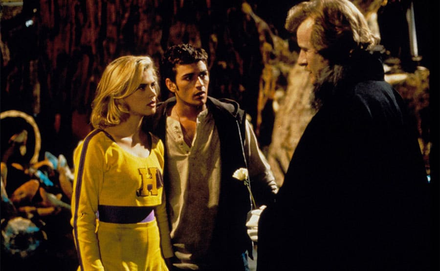 Kristy Swanson, Luke Perry, and Rutger Hauer standing around a party
