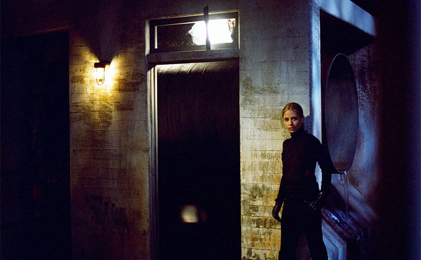 Sarah Michelle Gellar walking around a building dressed in tight all black clothes