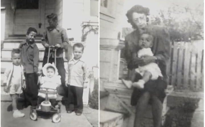 An old photograph of a family with children in front of a house and a mother holding a baby