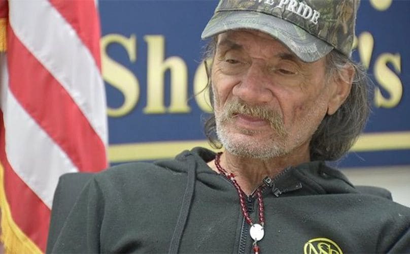 Mick Myers in front of an American Flag