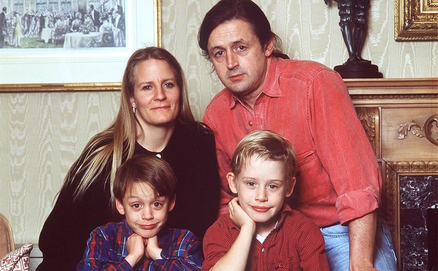 Patricia, Christopher, Kieran, and Macaulay Culkin posing together in the living room in 1990.