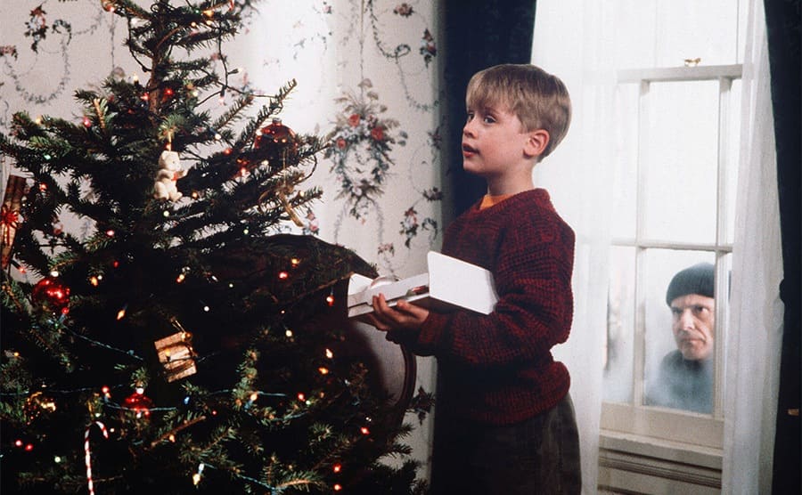 Macaulay Culkin and Joe Pesci in the window behind him in Home Alone